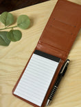 Load image into Gallery viewer, Personalised PU Leather A7 Notepad Holder – Custom Laser Engraved Pocket Notebook with Pen, Durable & Elegant Gift (Brown or Black) Krevana Personalised PU Leather A7 Notepad Holder – Custom Laser Engraved Pocket Notebook with Pen, Durable & Elegant Gift (Brown or Black)