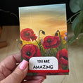 Load image into Gallery viewer, Notepad holder with Poppy Field original artwork print with inspiration message and the text 'YOU ARE AMAZING' on a white label.