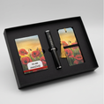 Load image into Gallery viewer, A black gift set box containing a black pen and two matching poppy-themed cards or bookmarks with a sunset field print, shown on a light gray background.
